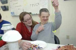 Megan Lamphear (Journeys Program Manager) admires the necklace that Andre Kish has created, during a typical day at the new Journeys facility in Bloomingdale.