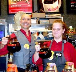 Employment4 Two wawa employees holding up coffee pots smiling