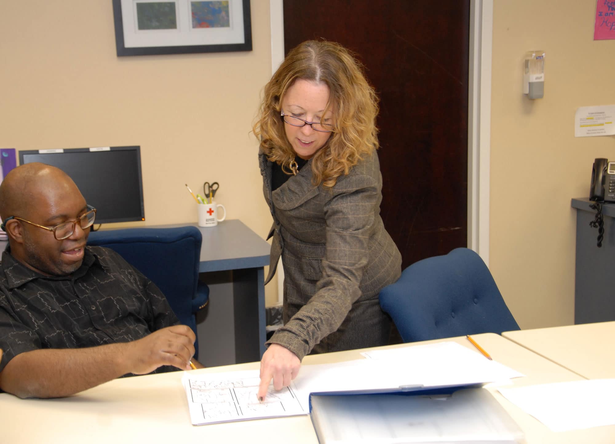 Eddie W., an employee at the Daily Plan It in Princeton, shows Elizabeth Connolly his comic book drawings.