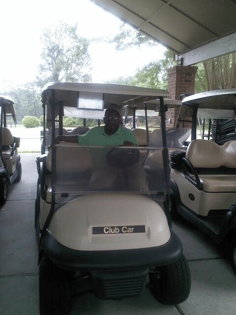 Clarence driving a golf cart around
