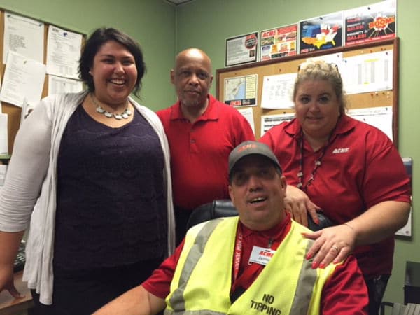 From left, Katrina Blaise, job coach at Community Options; Joe Brown, Community Options staffer and job coach; and Wendy Makai, manager at Acme, stand behind James Grubb, who has been helped by the jobs program and coaching by Community Options.