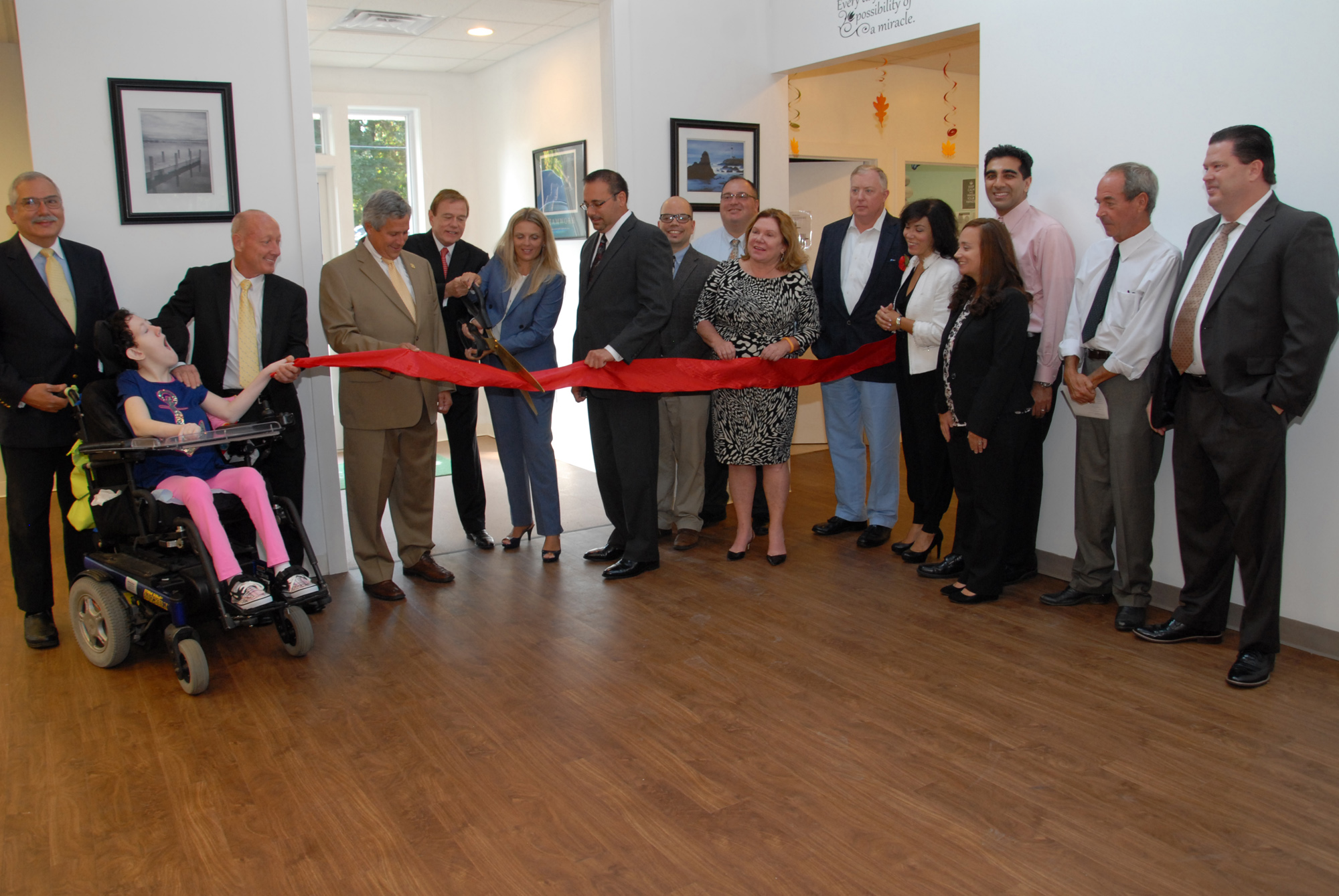 From left: Philip Lian, COE Board member; Kimberly Spano; James Spano, COE Board member; Senator Christopher 'Kip' Bateman; Robert Stack, President and CEO of Community Options, Inc.; Svetlana Repic-Qira , Community Options, Inc. Regional Vice President of New Jersey;Anthony Ferrera, Administrator/Deputy Township Clerk for Hillsborough Township; David Kois, Business Advocate for Hillsborough Township; Daniel Surtz, COE Board Member; Gail Gordon, COE Board Member; Alec Taylor, COE Board Member; Linda Thomas, member of the Red Ribbon Academy's Parent Group; Dr. Baber Ghauri, COE Board Member; Courtney Eidel, Chief Administrative Officer of Community Options, Inc.; Paul Hritz, COE Board Member and David Sweeney, Chief Financial Officer of Community Options, Inc open the new Red Ribbon Academy in Hillsborough, NJ.