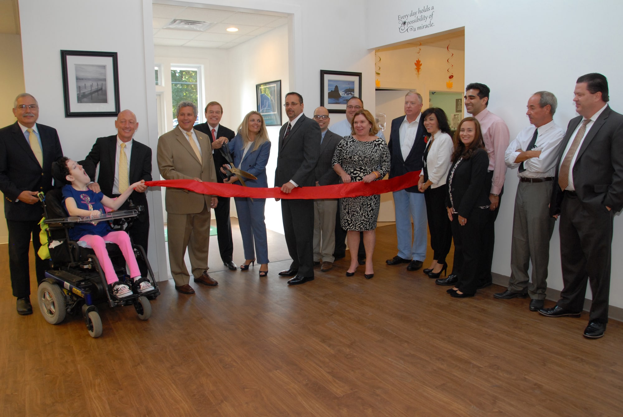 From left: Philip Lian, COE Board member; Kimberly Spano; James Spano, COE Board member; Senator Christopher 'Kip' Bateman; Robert Stack, President and CEO of Community Options, Inc.; Svetlana Repic-Qira , Community Options, Inc. Regional Vice President of New Jersey;Anthony Ferrera, Administrator/Deputy Township Clerk for Hillsborough Township; David Kois, Business Advocate for Hillsborough Township; Daniel Surtz, COE Board Member; Gail Gordon, COE Board Member; Alec Taylor, COE Board Member; Linda Thomas, member of the Red Ribbon Academy's Parent Group; Dr. Baber Ghauri, COE Board Member; Courtney Eidel, Chief Administrative Officer of Community Options, Inc.; Paul Hritz, COE Board Member and David Sweeney, Chief Financial Officer of Community Options, Inc open the new Red Ribbon Academy in Hillsborough, NJ.
