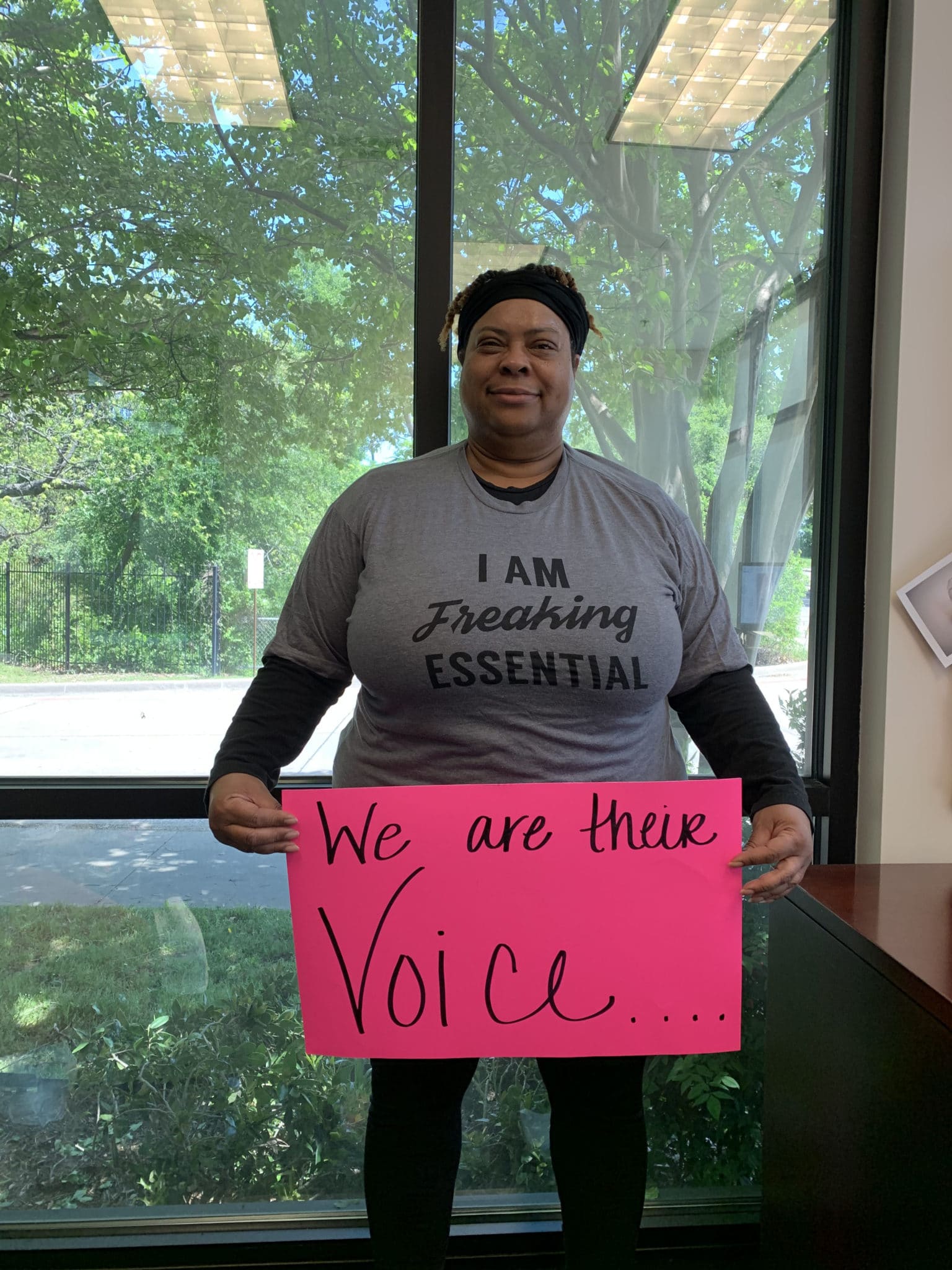 Fredricka Cross holding a poster that says, "We Are Their Voice"
