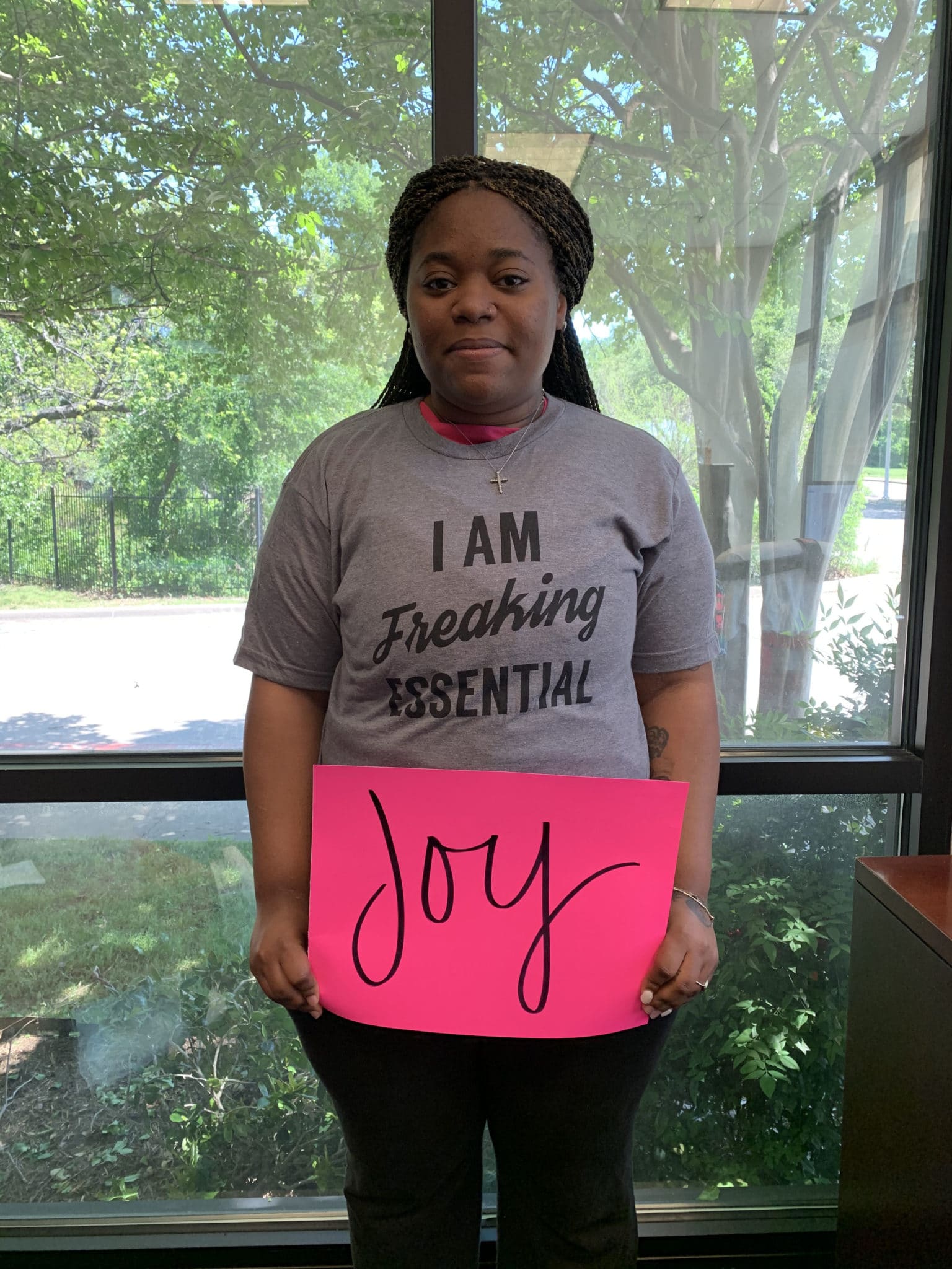 Willisha Ewing holding up a poster that says, "Joy"