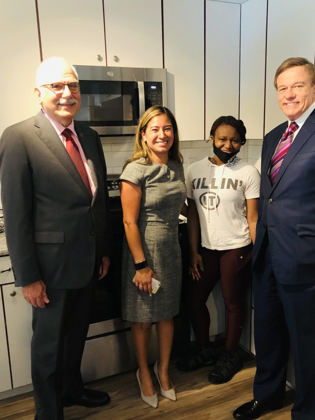 Phil Lian, Kathryn Bryant, and Robert Stack of Community Options join Veronica in her kitchen.