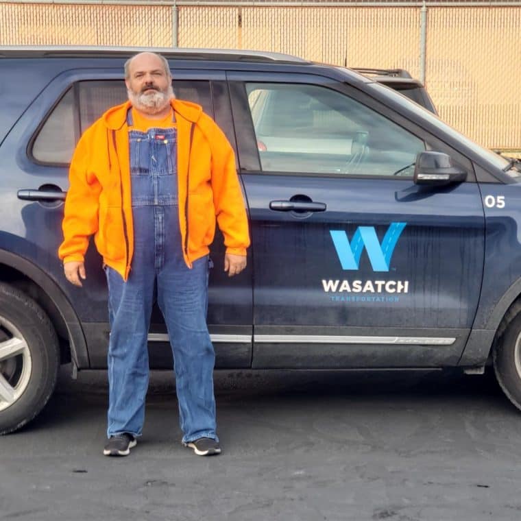 Kelly standing tall and proud in front of his work vehicle.