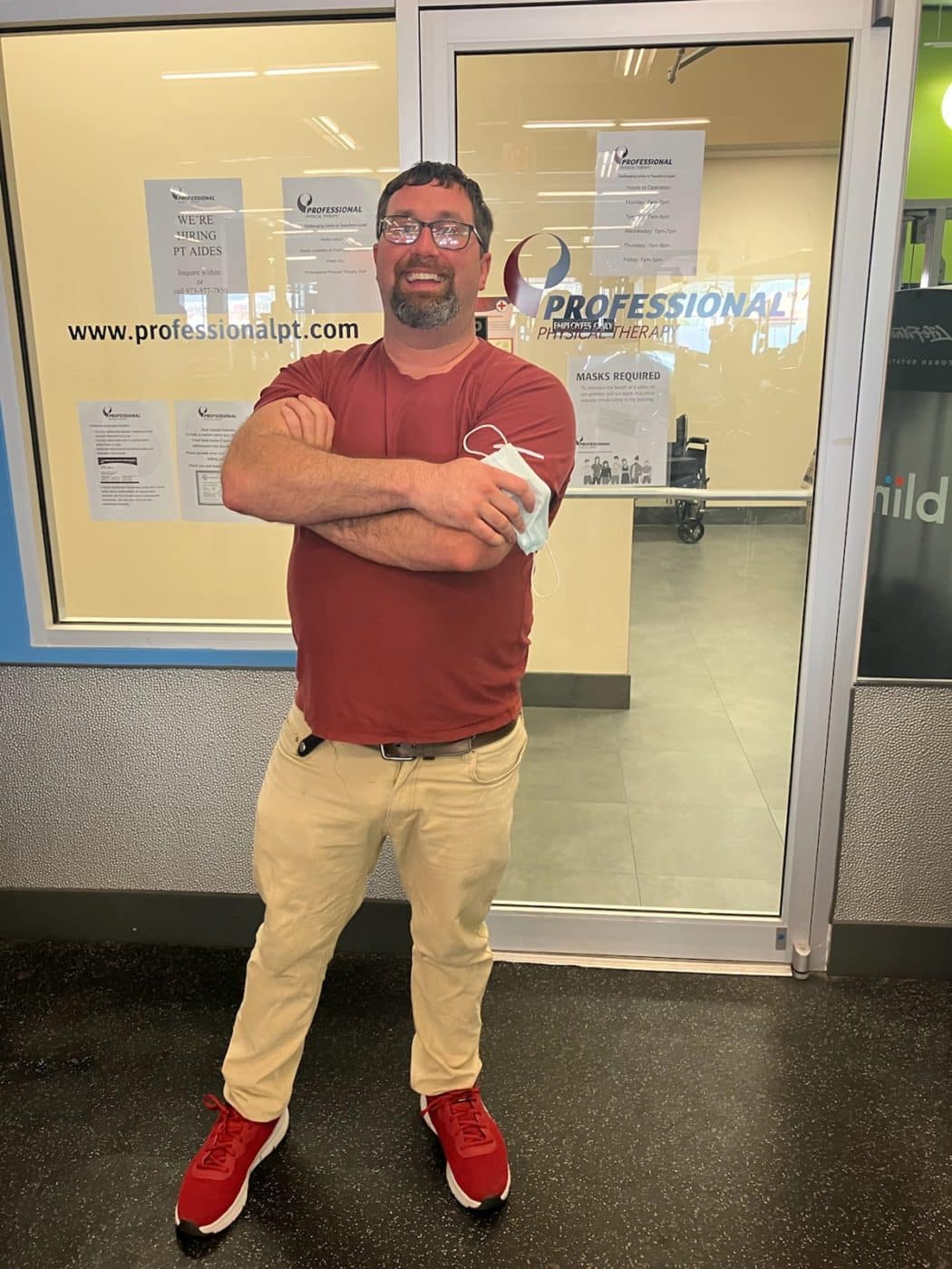Steven, proudly standing in front of his employer, “Professional Physical Therapy.”