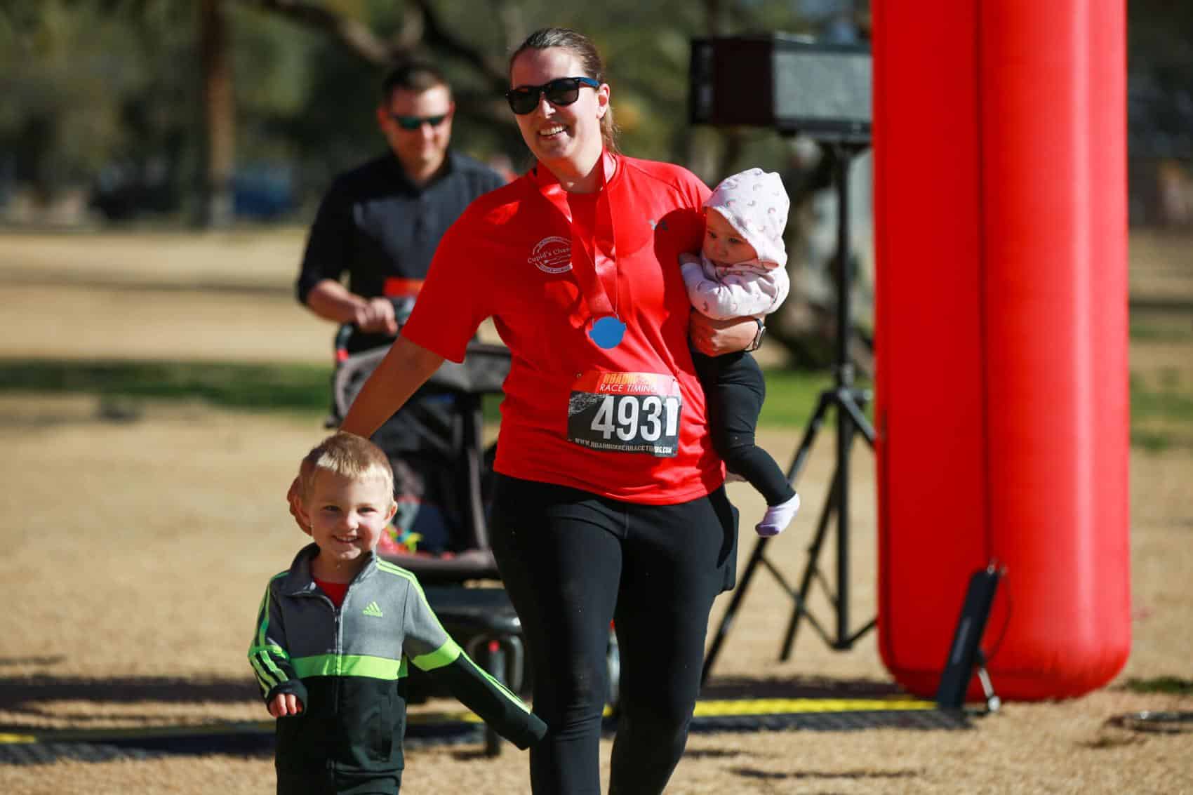Emily Veres crosses the finish line with her kids during the Cupid's Chase 5K Run on February 12, 2022 at Reid Park. Ana Beltran, Arizona Daily Star - tucson.com