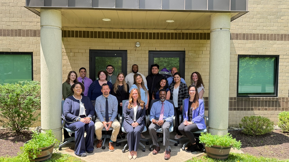 The Human Resources team outside of the Daily Plan It, 826 Alexander Road, Princeton, NJ 08540 office location posing together under an awning.