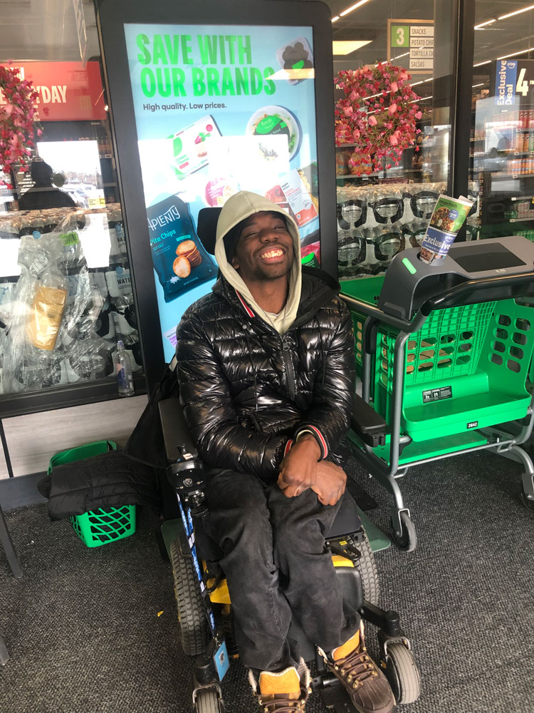 Nafis smiling and greeting customers at his job at Amazon Fresh