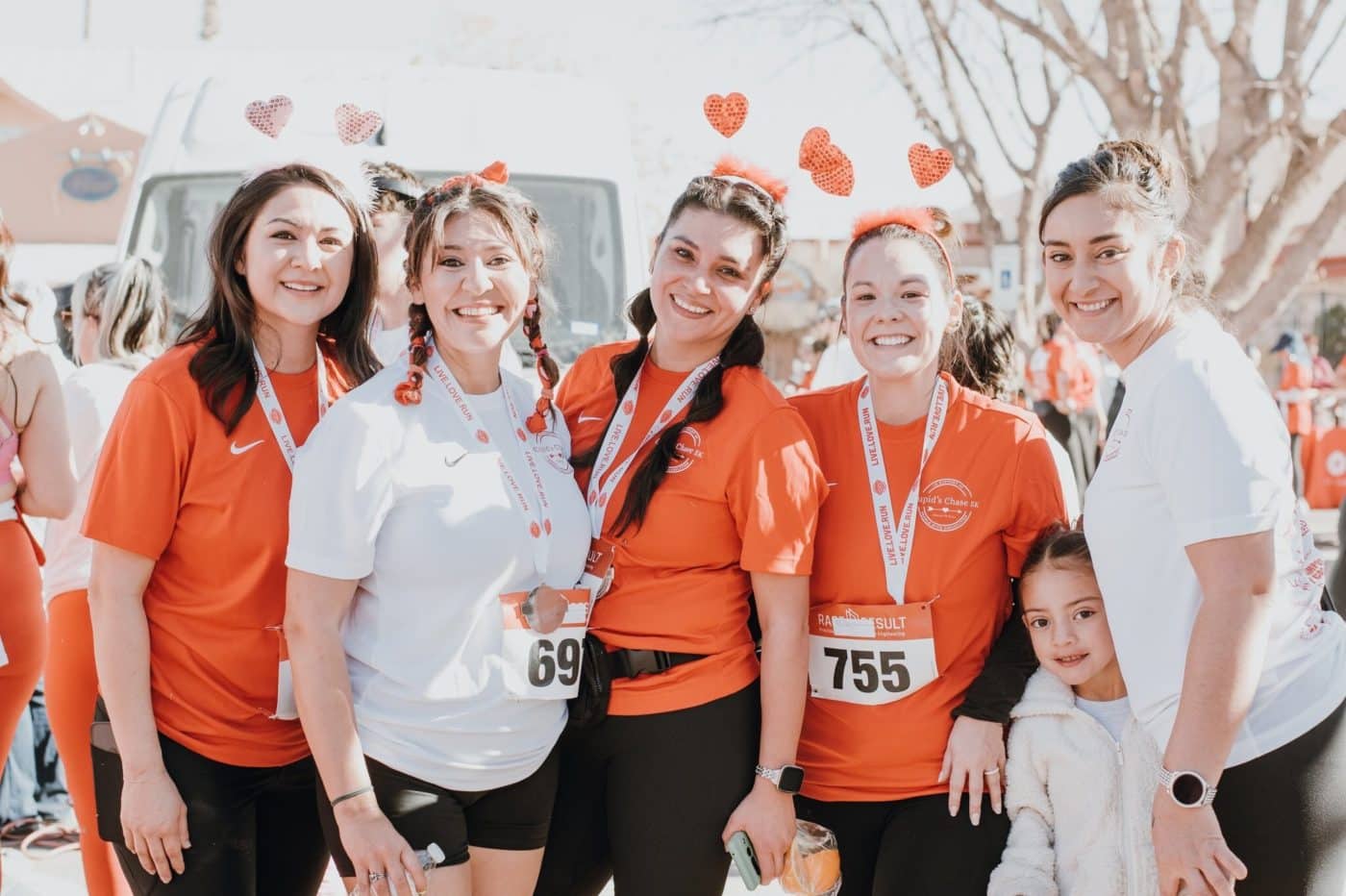 A group of 6 cupid's Chase runners dressed in valentines day heart headbands or red and white shirts.