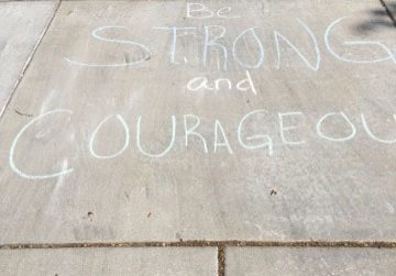 Be strong and courageous and other encouraging messages written with chalk on driveway.