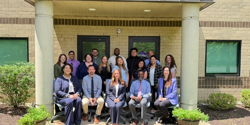 The Human Resources team outside of the Daily Plan It, 826 Alexander Road, Princeton, NJ 08540 office location posing together under an awning.