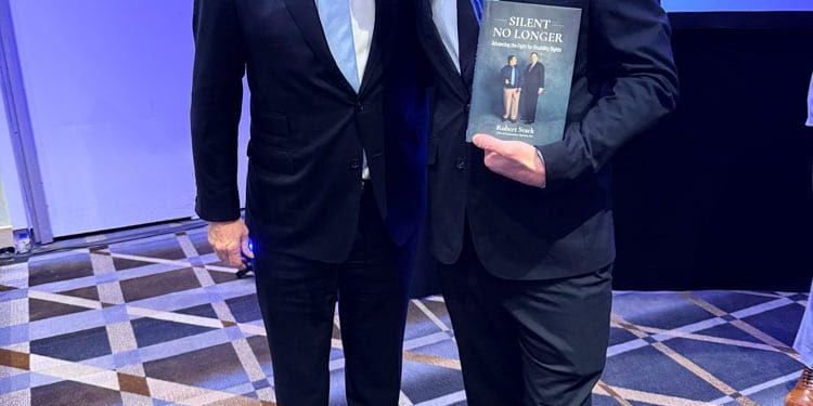 From left to right: Robert Stack and RJ Mitte at the Community Options’ We the People Conference in Washington, DC on October 20, 2025. RJ Mitte is holding a copy of the book Silent No Longer.