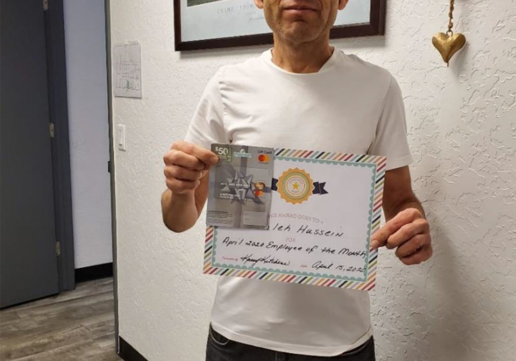 Saleh Hussien holding an award for 'Employee of the month'